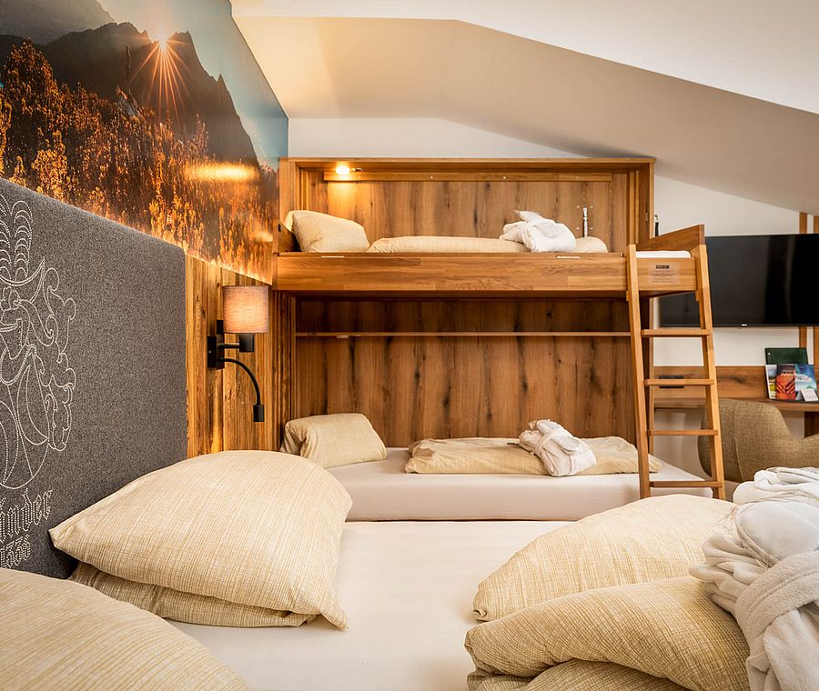 Detail of a family room with double bed, bunk bed and wooden details