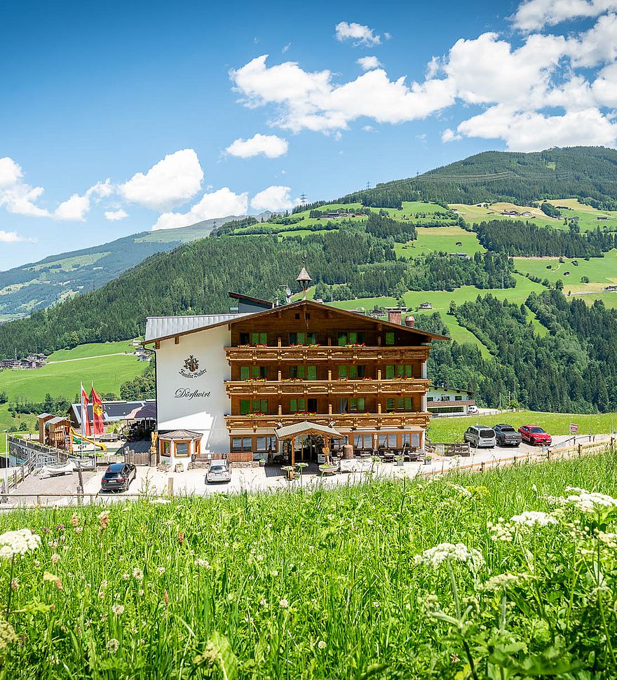 Zomerzicht op gasthof Dörflwirt met bloeiende alpenweiden in het Zillertal