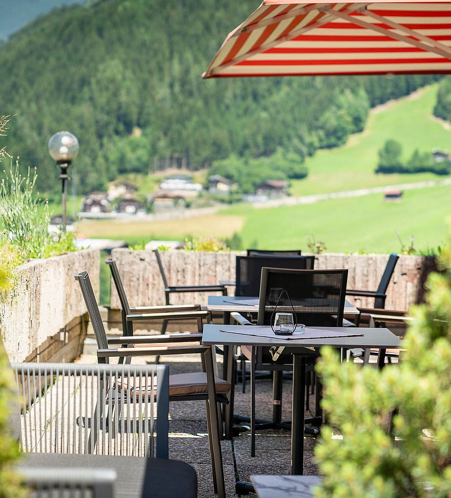 Terras met rood-witte parasol en prachtig uitzicht over het Zillertal