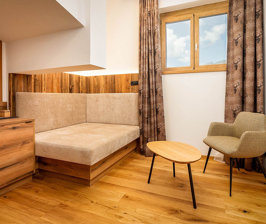 Cozy sitting area in hotel room with padded corner, table and chair
